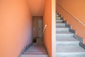 Eine Treppe mit Marmorstufen, die zu einer Tür am oberen Ende führt.