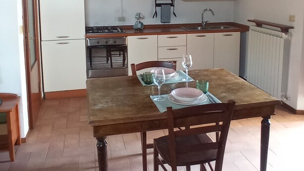 Una cucina con tavolo da pranzo, sedie e isola centrale.