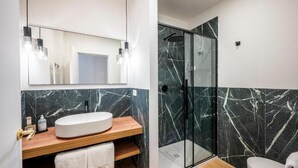 A modern bathroom with a marble vanity, a glass-enclosed shower, and a toilet. - Palazzo Garibaldi Parma (Parma)