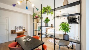 A modern living space with a dining area, a bookshelf, and a potted plant. - Palazzo Garibaldi Parma (Parma)