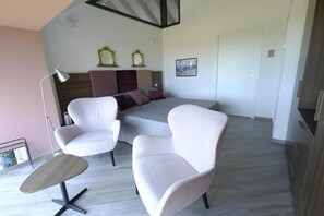 A modern bedroom with a bed, two white armchairs, a side table, a floor lamp, and a mirror on the wall. - Cirasa Luxury Country House (Trecastagni)