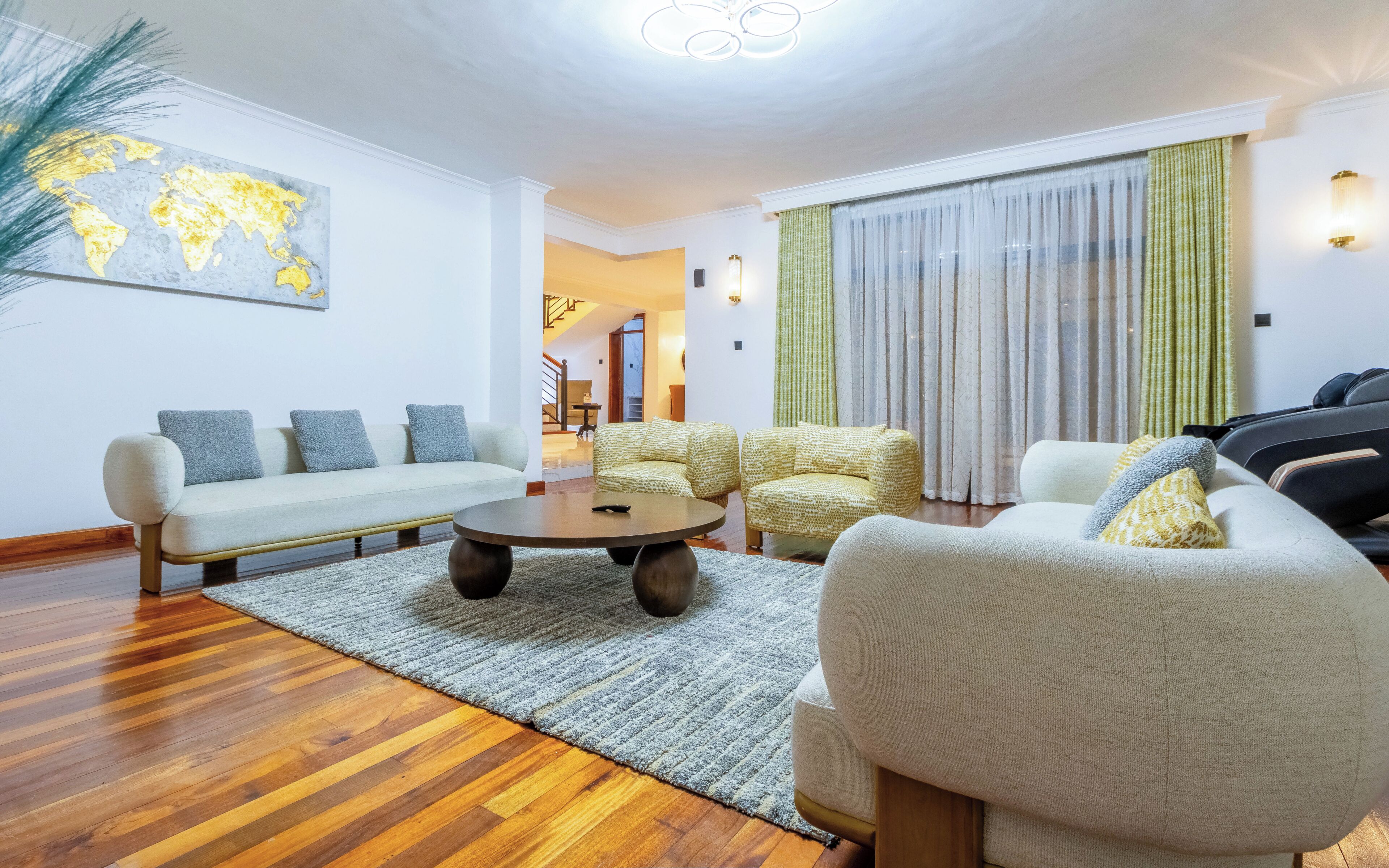 Uma sala de estar moderna com um conjunto de sofá, uma mesa de centro e um mapa-múndi na parede.