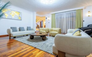 A modern living room with a sofa set, a coffee table, and a world map on the wall.