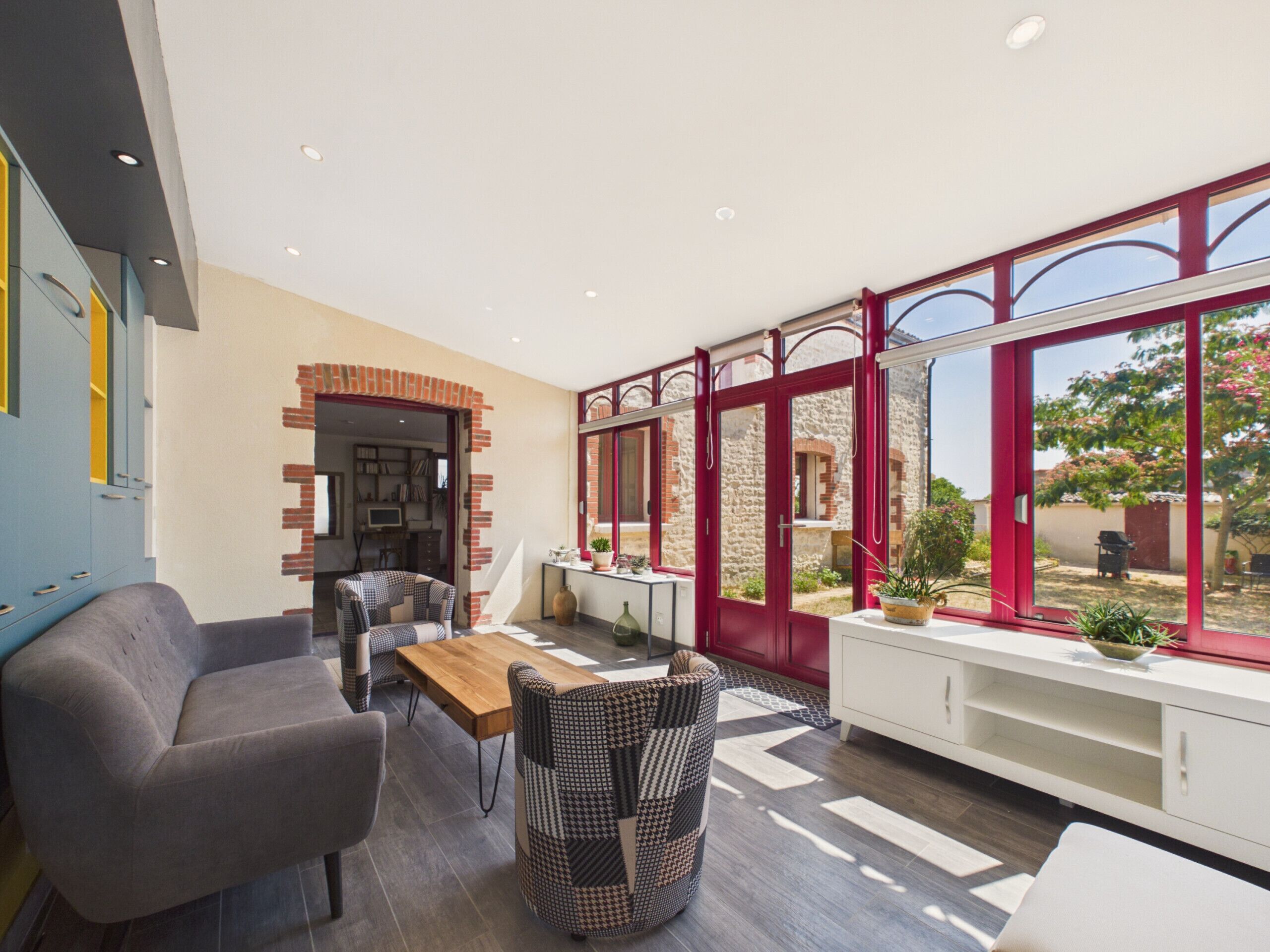 A modern interior with a dining area, a sofa, and a patterned chair.