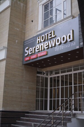 A hotel sign with the name 'HOTEL SERENEWOOD' and mentions 'rooms,' 'banquet,' and 'restaurant.' - SERENEWOOD BY ZENVANA (Dehradun)