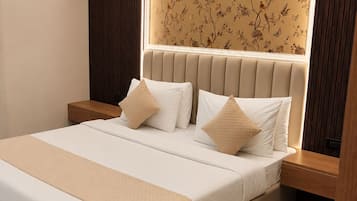Un dormitorio moderno con una cama grande, un cabecero estampado con motivos florales y una mesita de noche con detalles de madera.
