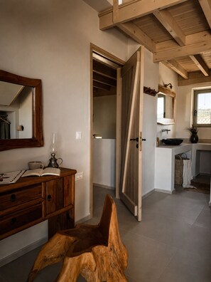 Ein Zimmer mit einem Holzkasten, einem Spiegel, einer Leselampe und einer Tür zu einem anderen Raum.