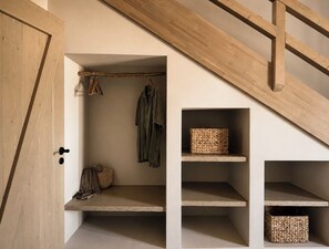 A storage area with wooden shelves, a bench, and hanging items. - Conte Maris Tower III - Sea View Mediterranean Escape (Tragaki)