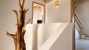 A staircase with a wooden trunk sculpture, white walls, and a wooden ceiling. - Conte Maris Tower III - Sea View Mediterranean Escape (Tragaki)