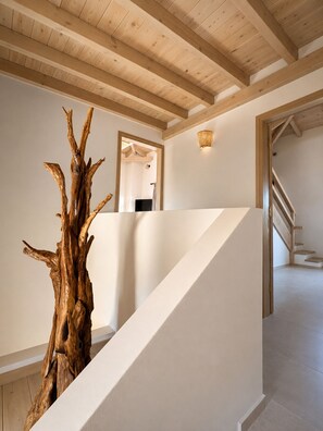 Eine Treppe mit einer Skulptur eines hölzernen Truhens, weißen Wänden und einer Holzboden.