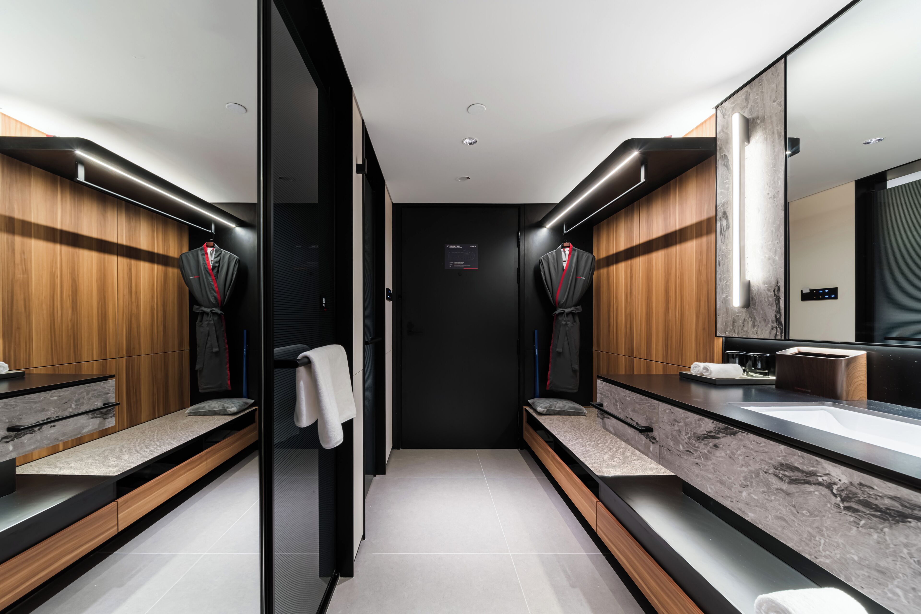 Ein modernes Badezimmer mit zwei Waschbecken, Holzverkleidung und einem großen Spiegel.