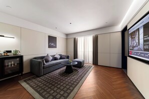Ein modernes Wohnzimmer mit einer Couch, einem Couchtisch, einem Fernseher und Holzboden.