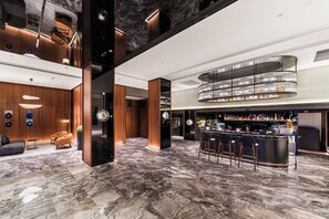 Uma área de bar moderna com piso de mármore e balcão curvo.