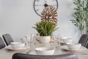 A dining table set with white bowls, glasses, and a potted fern centerpiece. - Hurricane 3BR - Hot Tub & Mountain Views (Hurricane)
