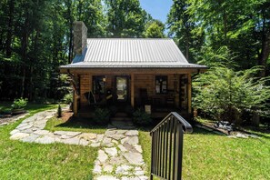 A wooden cabin with a stone pathway leading to the entrance, surrounded by trees. - The Little Deer Cabin - Hot Tub, Stone Fireplace (Pounding Mill)