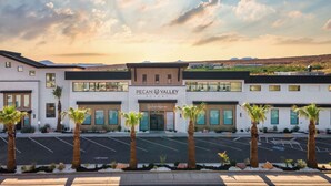 Ett modernt hotell med en tydlig skylt som visar namnet ”PECAN VALLEY RESORT” och en avdelning som kallas ”BeachHouse”.