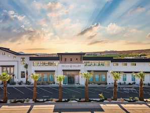 Ein modernes Hotel mit einem gut sichtbaren Schild für 'PECAN VALLEY RESORT' und einem Bereich namens 'BeachHouse'.