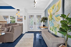 A living room with two sofas, a coffee table, and a painting on the wall. - Private Pool + Spa + Outdoor Dining | Gulf Beaches | Blue Sunset (Bonita Springs)