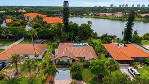 A residential area with houses, a swimming pool, and a lake. - Private Pool + Spa + Outdoor Dining | Gulf Beaches | Blue Sunset (Bonita Springs)