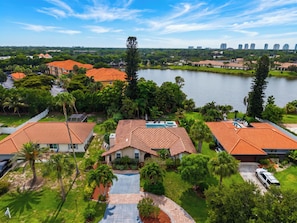 A residential area with houses, a swimming pool, and a lake. - Private Pool + Spa + Outdoor Dining | Gulf Beaches | Blue Sunset (Bonita Springs)