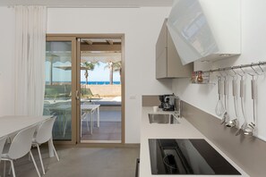 Eine kompakte Küche mit Einbauofen, Kaffeemaschine und Spüle.