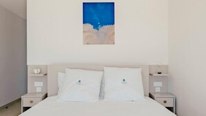 Ein Schlafzimmer mit einem Bett, zwei Nachttischen und einem Wandbild.