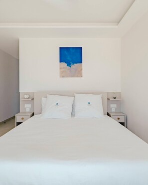 A bedroom with a bed, two nightstands, and a wall-mounted painting. - New sea view Villa w/ private Pool and Jacuzzi - Sxm
Villa Noé (St Martin)