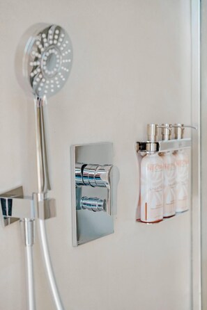 A shower with a handheld showerhead and a wall-mounted soap dispenser. - New sea view Villa w/ private Pool and Jacuzzi - Sxm
Villa Noé (St Martin)