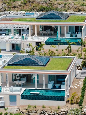 Un complexe hôtelier moderne composé de plusieurs bâtiments, chacun doté de jardins sur les toits, de piscines et d’espaces de détente en plein air.