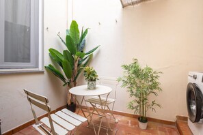 A small room with a window, a washing machine, a table with chairs, and two potted plants. - Experience the authentic charm of Florence in this elegant apartment located on Via Sant'Onofrio, in the historic Oltrarno district—one of the city's most charming, authentic, and sought-after neighborhoods.Blending contemporary design with carefully s (Firenze)