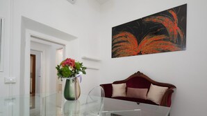 Um interior moderno com uma mesa de centro de vidro, um sofá vermelho e uma pintura abstrata pendurada na parede.