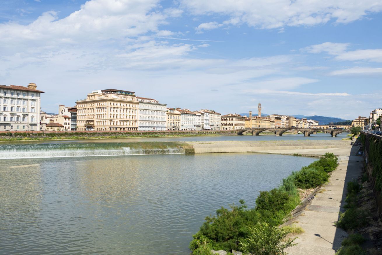 A river with bridges, buildings, and a clear sky.