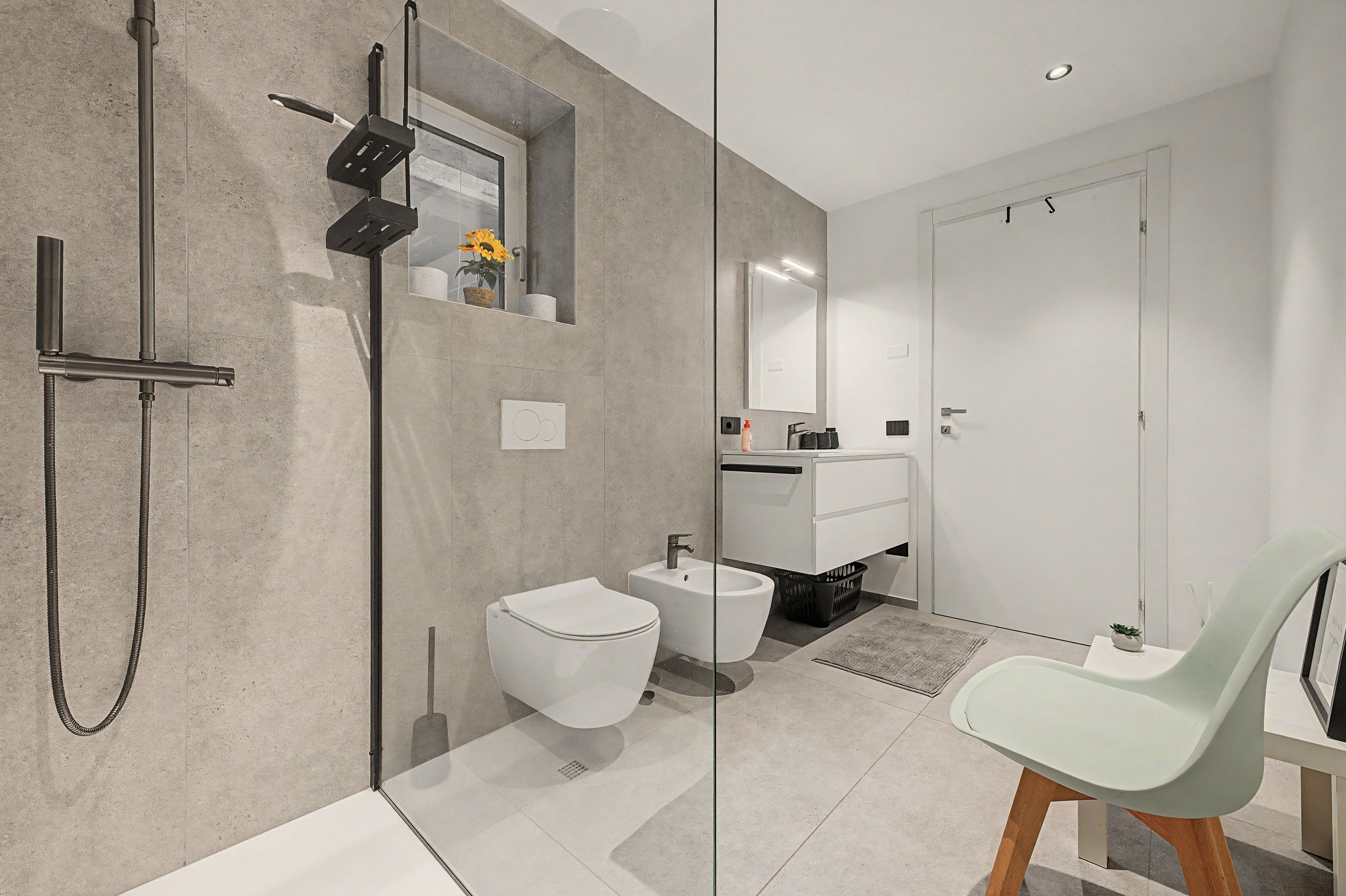 Un baño moderno con ducha, bidé e inodoro.