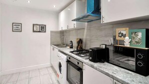 A modern kitchen with a built-in oven, a gas stove, and a coffee maker. - Belvedere 4-bed Apt, Sleeps 9 With Parking (Belvedere)