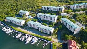 Um resort com vários edifícios, um areal e vegetação exuberante.