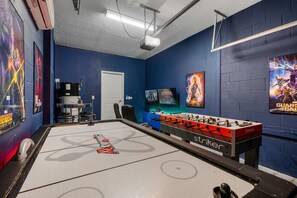 A room with a foosball table, a projector, and movie posters on the walls. - 1576 Flange Drive (Davenport)
