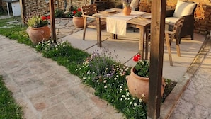 An outdoor patio with a brick wall, wooden pergola, and seating area. - Charming 2-floor Apartment With Vineyard Views in Morro D'alba (Morro d'Alba)