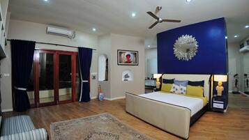 A bedroom with a bed, bedside tables, a ceiling fan, and a large decorative mirror.