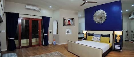 A bedroom with a bed, bedside tables, a ceiling fan, and a large decorative mirror.