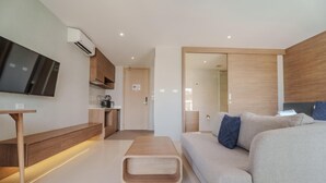 Een moderne woonkamer met een bank, een salontafel en een tv aan de muur.