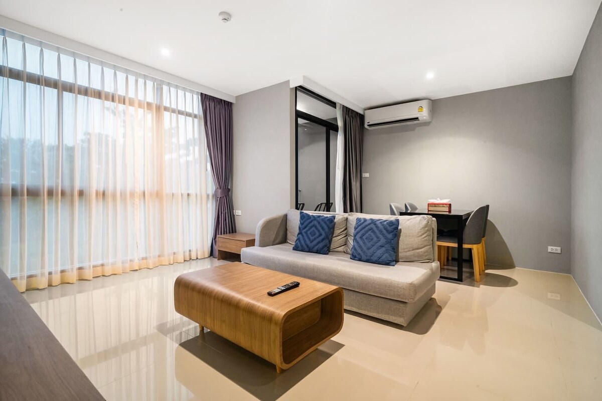 Uma sala de estar moderna com sofá, mesa de centro e espaço para refeições.