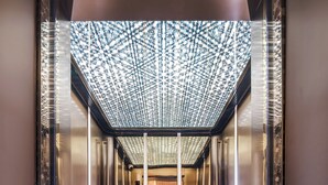 An elevator interior with a patterned ceiling, a carpet with directional arrows, and the word 'CRYSTAL' on the floor. - Crystal Hotel Shanghai Hongqiao Qianwan (Shanghai)