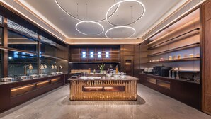 A modern kitchen with a central island, built-in appliances, and a large window. - Crystal Hotel Shanghai Hongqiao Qianwan (Shanghai)