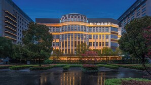 A hotel with a modern architectural design, featuring a curved facade and illuminated signage. - Crystal Hotel Shanghai Hongqiao Qianwan (Shanghai)