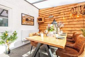 A wooden dining table with chairs, a potted plant, and a framed sign on the wall. - Vacation Home "Westerlön Hüs 1999" (Sylt)