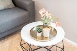 A round table with a white marble top, a small potted succulent, and a vase with pink flowers. - Vacation Home "Westerlön Hüs 1999" (Sylt)