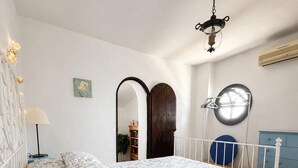 Ein Schlafzimmer mit einem Bett, einer Lampe, einem Spiegel und einem Kleiderschrank.