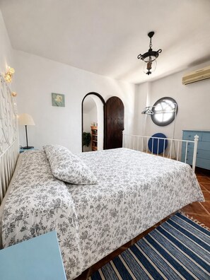 A bedroom with a bed, a lamp, a mirror, and a wardrobe. - The Courtyard of the Soul (villanueva de la concepción)