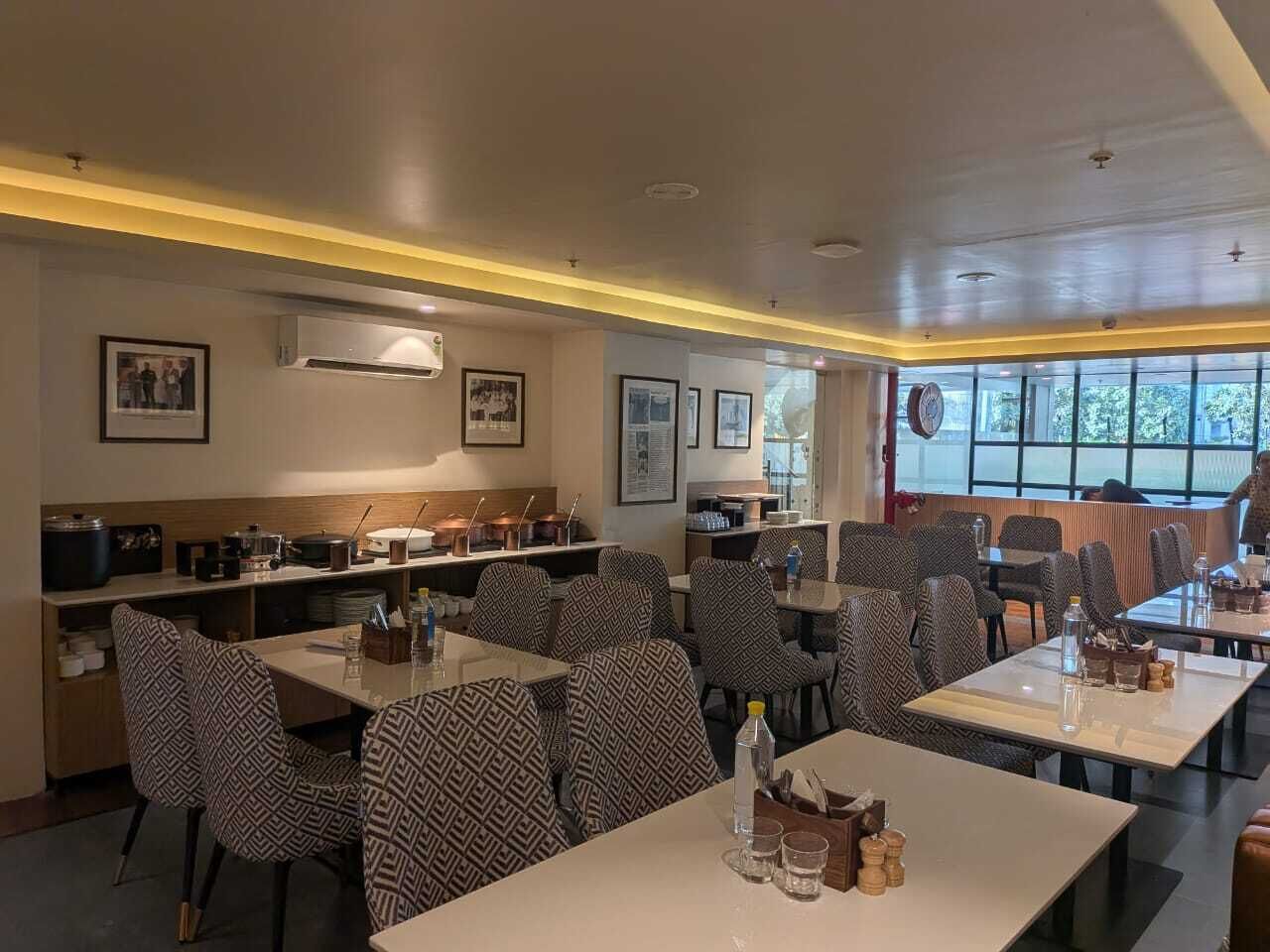 Un restaurante con sillas, mesas y una zona de bufé.