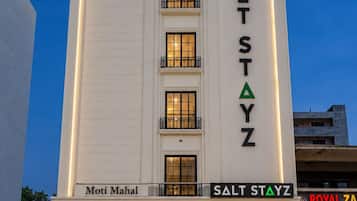 Un hotel llamado 'Salt Stayz' con una fachada moderna, varios ventanales y un letrero de 'Moti Mahal' en la entrada.